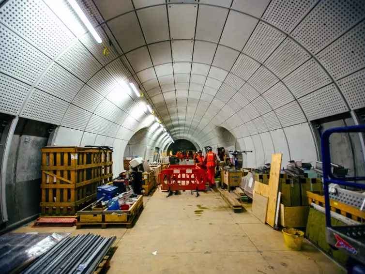 Men in hi-vis working in underground tunnel.